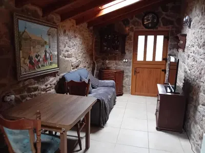 a living room with a table and a couch at Stone Cottage La COMPOSTELANA in Curtis