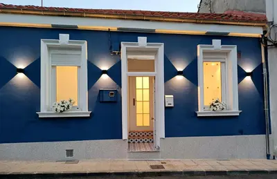 a blue house with three windows and a door at Casa Jardín in Monforte de Lemos