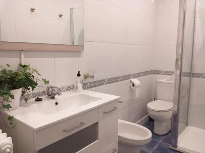 a white bathroom with a sink and a toilet at Casa Jardín in Monforte de Lemos