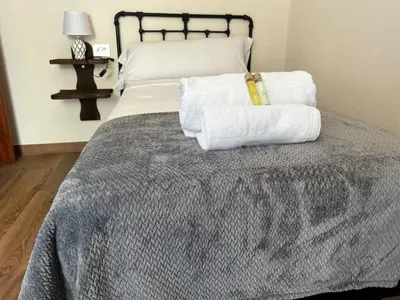 a bedroom with a bed with towels on it at Castiñeiras Street in Sarria