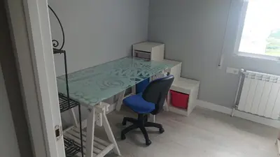 a desk with a blue chair and a glass table at Foz Playas in Foz