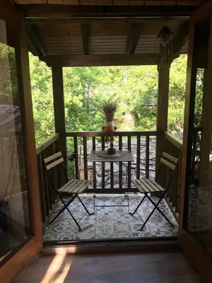 a screened in porch with a table and two chairs at A curuxa casa rural in El Mazo