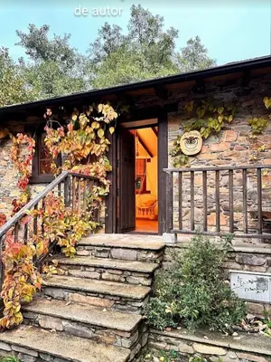 a stone house with stairs leading to a door at A curuxa casa rural in El Mazo