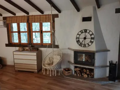 a living room with a clock and a fireplace at A curuxa casa rural in El Mazo