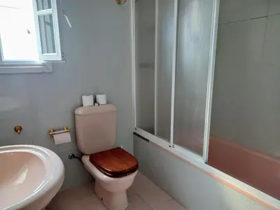 a bathroom with a toilet with a sink and a shower at Ático Pilos in Castro Caldelas