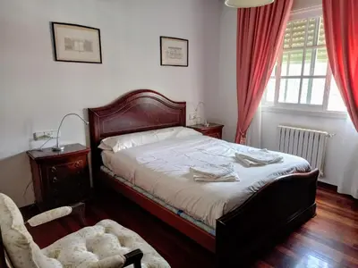 a bedroom with a bed and a chair and a window at Ático Pilos in Castro Caldelas