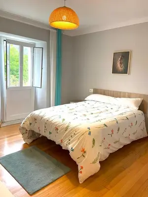 a bedroom with a bed with a blanket on it at Casa Concha do Caserón do Viaxeiro in Mondoñedo