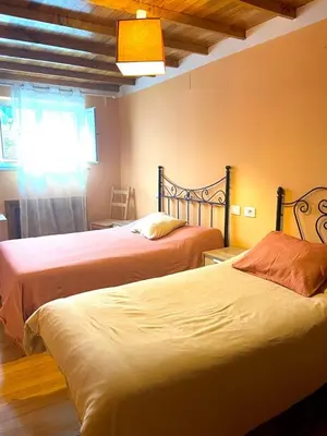 a bedroom with two beds and a window at Casa Concha do Caserón do Viaxeiro in Mondoñedo