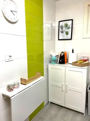 a kitchen with green and white walls and a clock at Casa Concha do Caserón do Viaxeiro in Mondoñedo