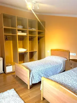a bedroom with two beds and a book shelf at Casa Concha do Caserón do Viaxeiro in Mondoñedo