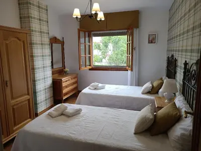 a bedroom with two beds and a window at LA CAMELIA in Pontevedra