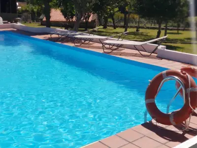 a pool with chairs and a lifesaver next to it at LA CAMELIA in Pontevedra