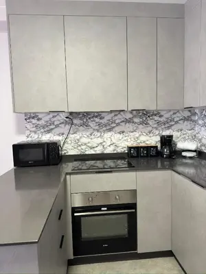 a kitchen with white cabinets and a stove top oven at Apartamento a 5 minutos del casco histórico in Viveiro