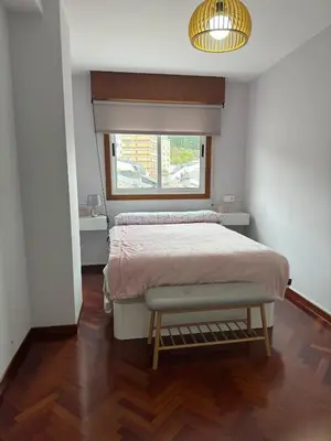 a bedroom with a large bed and a window at Apartamento a 5 minutos del casco histórico in Viveiro