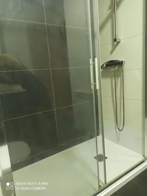 a shower with a glass door in a bathroom at Aroalia, super céntrico!! in Ourense