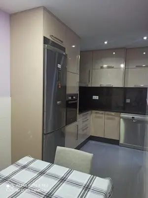 a kitchen with a refrigerator and a chair in it at Aroalia, super céntrico!! in Ourense