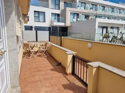a balcony with a table and chairs and a building at Apartamento en Playa Rapadoira in Foz