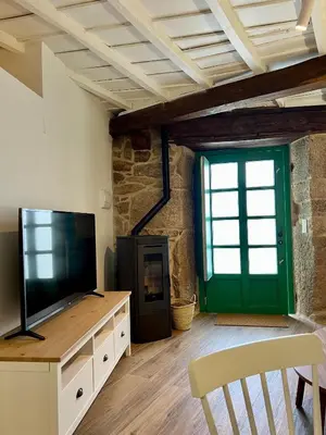 a living room with a television and a green door at A Parada House by Kev in Parada del Sil