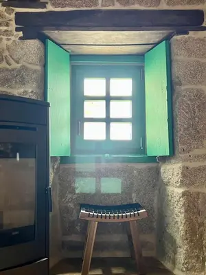 a bench in front of a window in a room at A Parada House by Kev in Parada del Sil