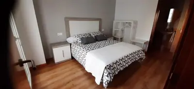 a bedroom with a bed with black and white sheets at Piso puerto Foz in Foz