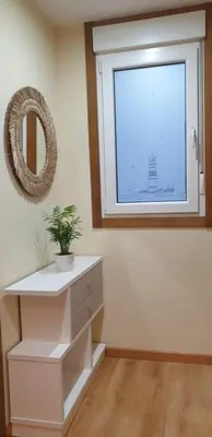 a room with a window and a white dresser with a plant at Piso puerto Foz in Foz