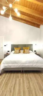 a bedroom with a large white bed and wooden floors at Precioso Apartamento 2 Hab. con Bañera Hidromasaje in O Barco de Valdeorras