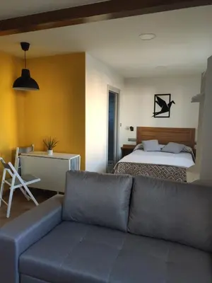 a living room with a couch and a bed at A Casiña do Camiño in Baamonde