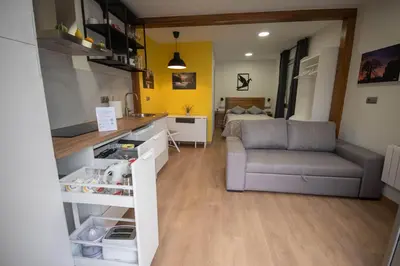 a kitchen and living room with a couch and a table at A Casiña do Camiño in Baamonde