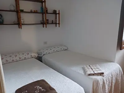 two twin beds in a room with shelves on the wall at Casa de Alicia Pontevedra Moraña Rías Baixas Casa Entera VT-PO-OOOO32 in Moraña