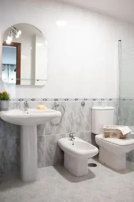 a bathroom with a sink and a toilet and a mirror at Luxury Singular Apartments Green in Santiago de Compostela