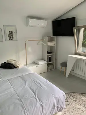 a white bedroom with a bed and a tv at ESPEJO DE SOLEDADES in Vigo de Sanabria
