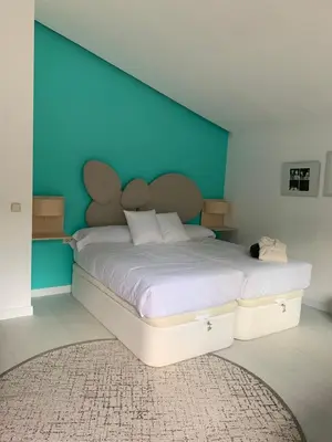 a bedroom with a large bed with a blue headboard at ESPEJO DE SOLEDADES in Vigo de Sanabria