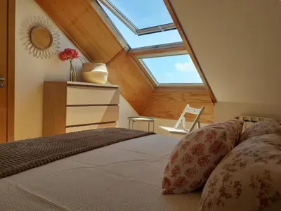 a bedroom with a bed and a skylight at Atico con terraza y piscina comunitaria in Ribadeo