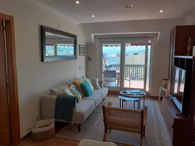 a living room with a couch and a table at Atico con terraza y piscina comunitaria in Ribadeo