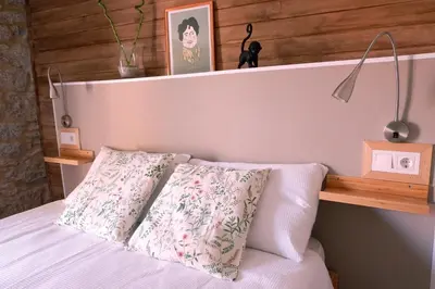 a bed with a wooden headboard with two pillows at A casa da Penela in Sas de Penelas