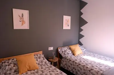 a bedroom with two beds and paintings on the wall at A casa da Penela in Sas de Penelas