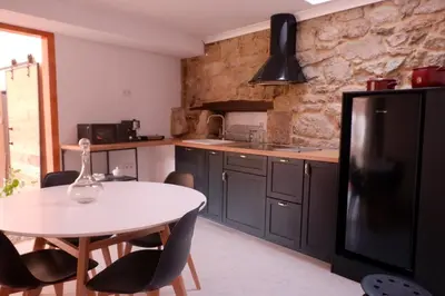 a kitchen with a white table and a black refrigerator at A casa da Penela in Sas de Penelas