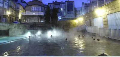 a group of people in a swimming pool at night at New J&J Hostel in Ourense