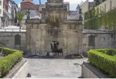 a stone building with a fountain in a courtyard at New J&J Hostel in Ourense