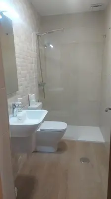 a bathroom with a sink and a toilet and a shower at New J&J Hostel in Ourense