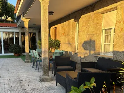 a patio with chairs and tables and a building at Casa Santa Ana in Tourón