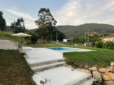 a swimming pool in a yard with an umbrella at Casa Santa Ana in Tourón