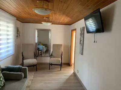 a living room with two chairs and a television on the wall at Casa ferreiro in Ribadeo
