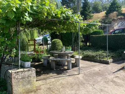 a picnic table under a tree in a garden at Casa ferreiro in Ribadeo
