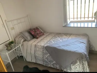 a small bedroom with a bed and a window at Casa ferreiro in Ribadeo