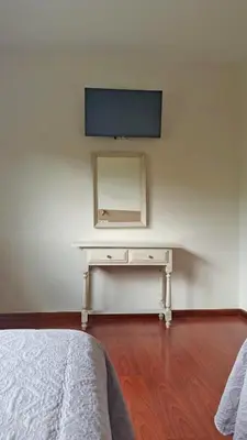 a white desk with a mirror and a tv on a wall at HOTEL RST. PADORNELO in Padornelo