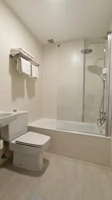 a white bathroom with a toilet and a bath tub at HOTEL RST. PADORNELO in Padornelo