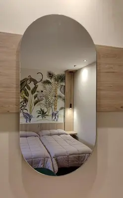 a mirror on a wall with a bed in a room at HOTEL RST. PADORNELO in Padornelo