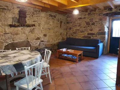 a living room with a table and a blue couch at A Palleira de Aguil in Castro Caldelas