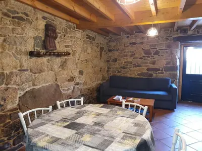 a living room with a table and a blue couch at A Palleira de Aguil in Castro Caldelas